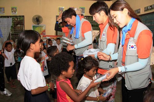 Student-volunteers from the Youngsan University in Seoul, South Korea distribute toothbrush kits to Ayta students at the Pastolan Village, an indigenous tribal community inside the Subic Bay Freeport, during an outreach project coordinated by the SBMA Public Relations Department last Friday.