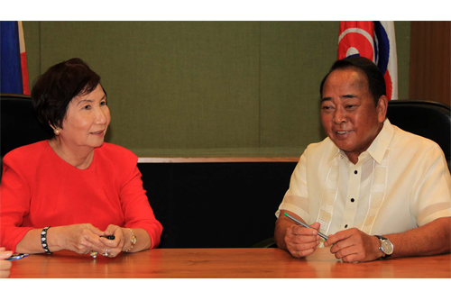 Quiz Bee President Gloria P. Tayag discusses the firmâ€™s development program with SBMA Chairman Roberto V. Garcia during the signing of a new lease development contract for the Subic school.