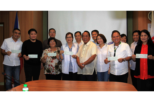 Local government officials show the cheques they received from SBMA Chairman Roberto Garcia (fourth from right) during the turnover of LGU shares for the first half of 2016.