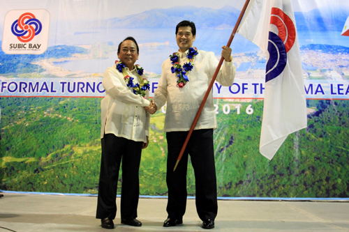 Outgoing SBMA Chairman Roberto V. Garcia (left) turns over the agencyâ€™s flag to newly-appointed Chairman Martin V. DiÃ±o in a formal ceremony on Monday at the Subic Bay Exhibition and Convention Center.