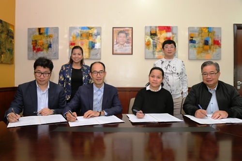 SBMA administrator and CEO Wilma Eisma and DMLeisure president Suyong Kim (second from left) sign a lease and development agreement for a P3.6-billion leisure development project in the Subic Bay Freeport. Signing as witnesses are a senior DMLeisure official and SBMA director Tomas Lahom III (right).