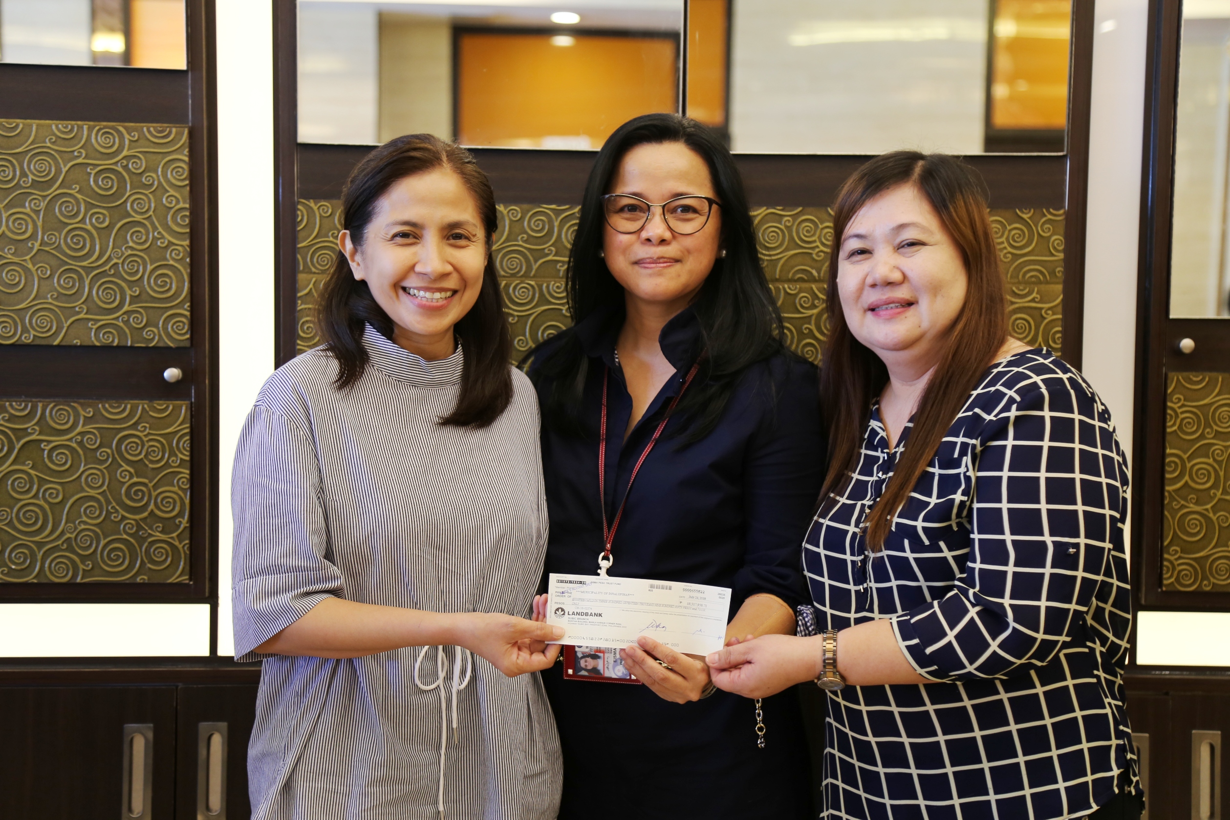 SBMA Chairman and Administrator Wilma T. Eisma (middle) hands over a check for the LGU share of Dinalupihan, Bataan to Mayor Ma. Angela Garcia (left) and another municipal official