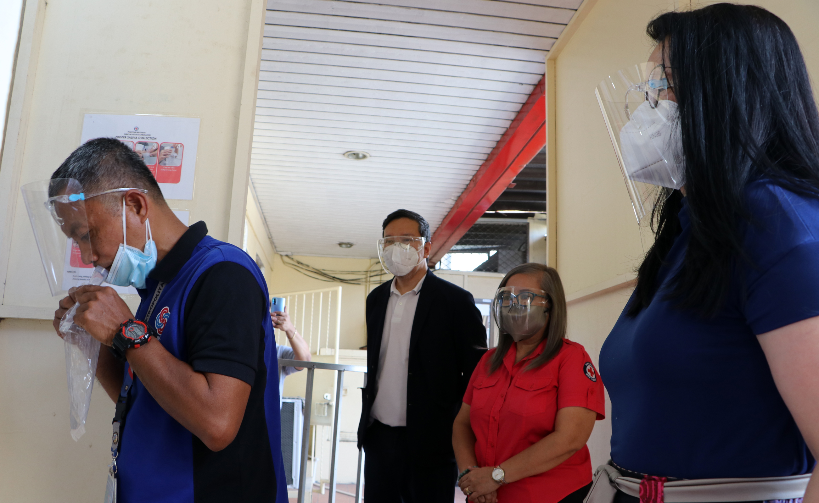 Emergency Medical Services staff Marcelo Macariola demonstrates the collection of saliva specimen forÂ testing during the launch of the saliva testing facility in Subic on Monday. Also in photo are SBMA Chairman and Administrator Wilma T. Eisma, PRC-Olongapo Administrator Vilma T. Feji, and SBMA Deputy Administrator for Health and Safety Ronnie Yambao.
