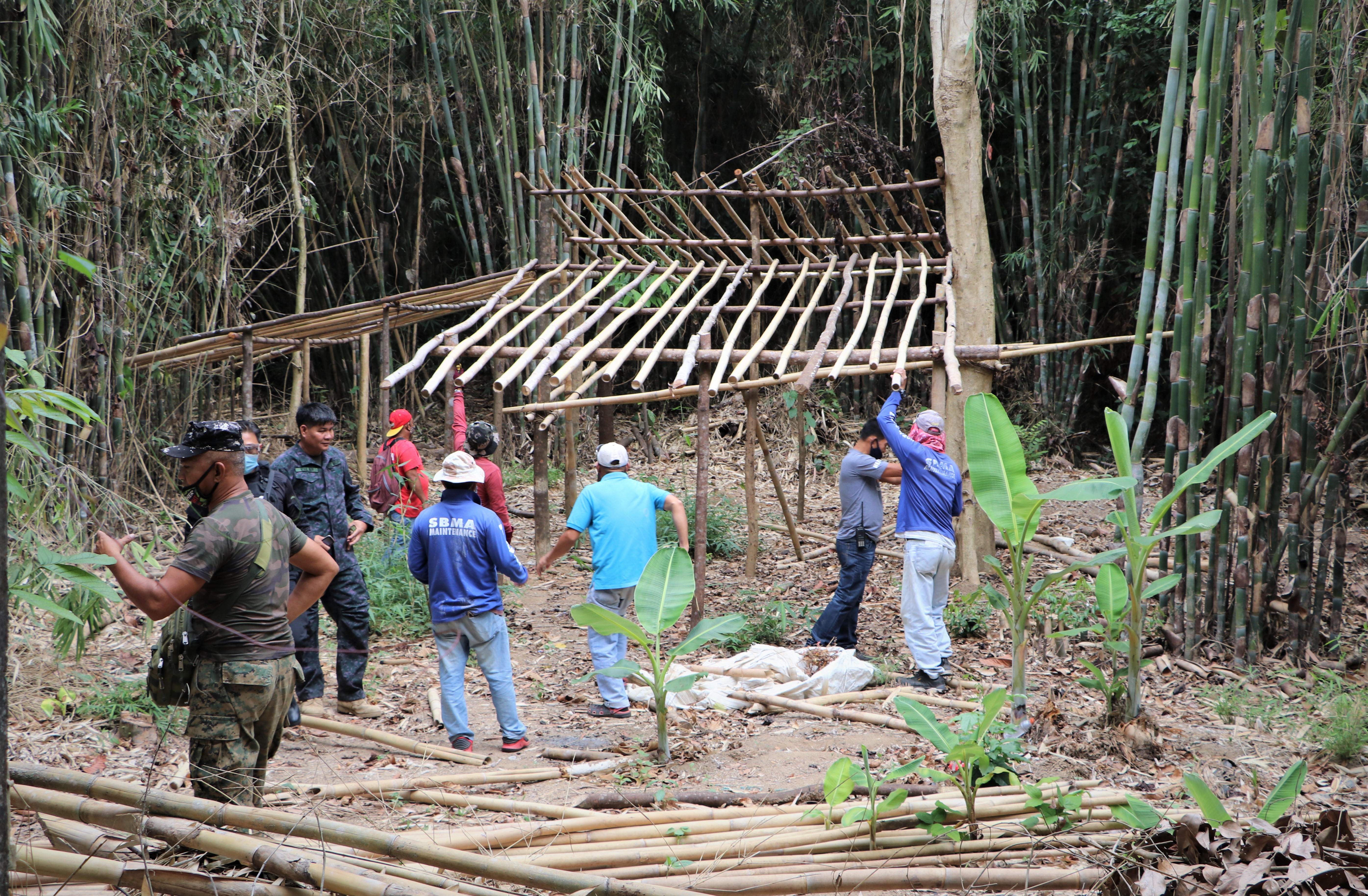 SBMA workers start dismantling a hut built in an illegally-cleared area near the Subic Bay Expressway