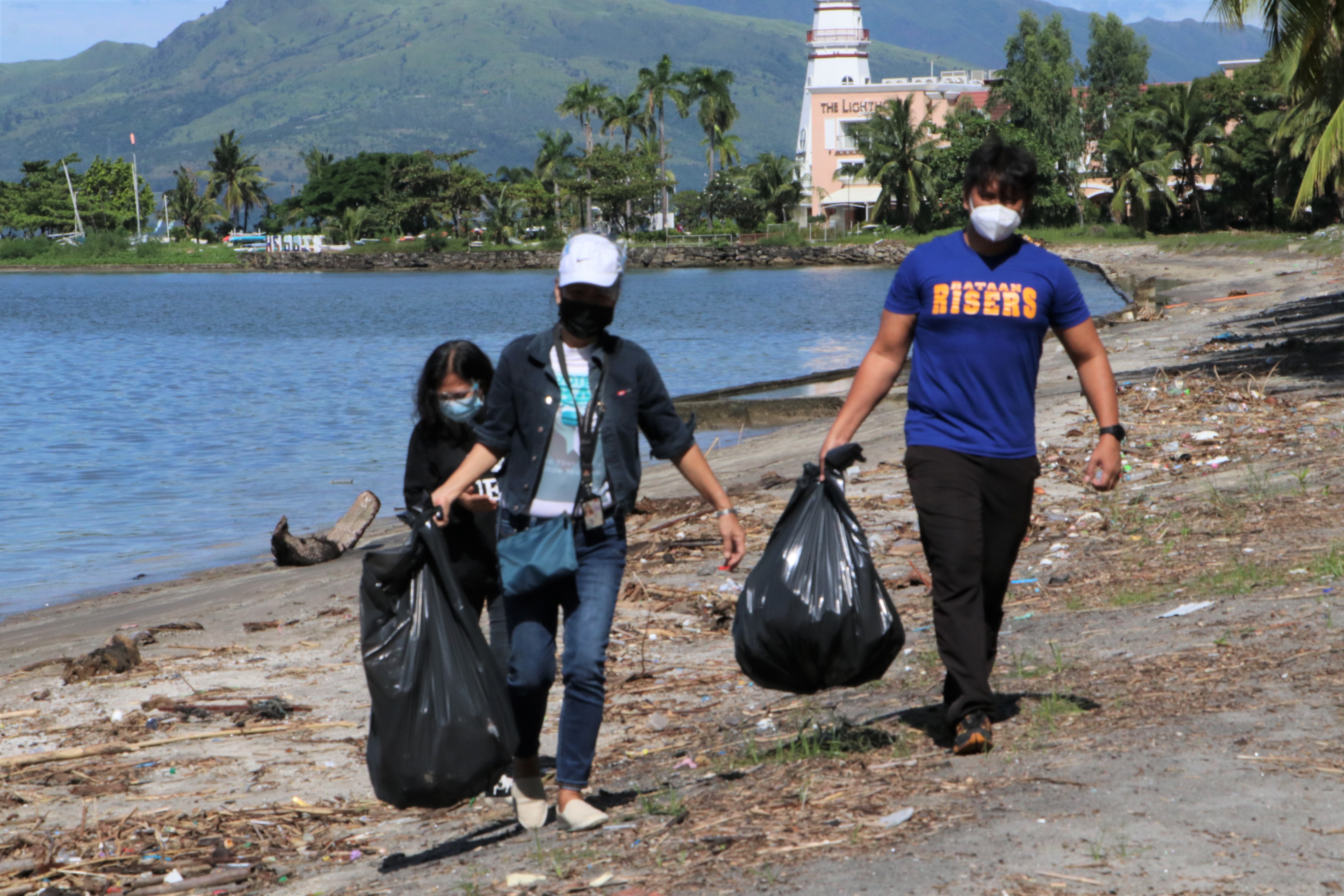 Participants in the 2021 coastal cleanup scour the shoreline in the Subic Bay Freeport to collect wastes and storm debris washed on shore.