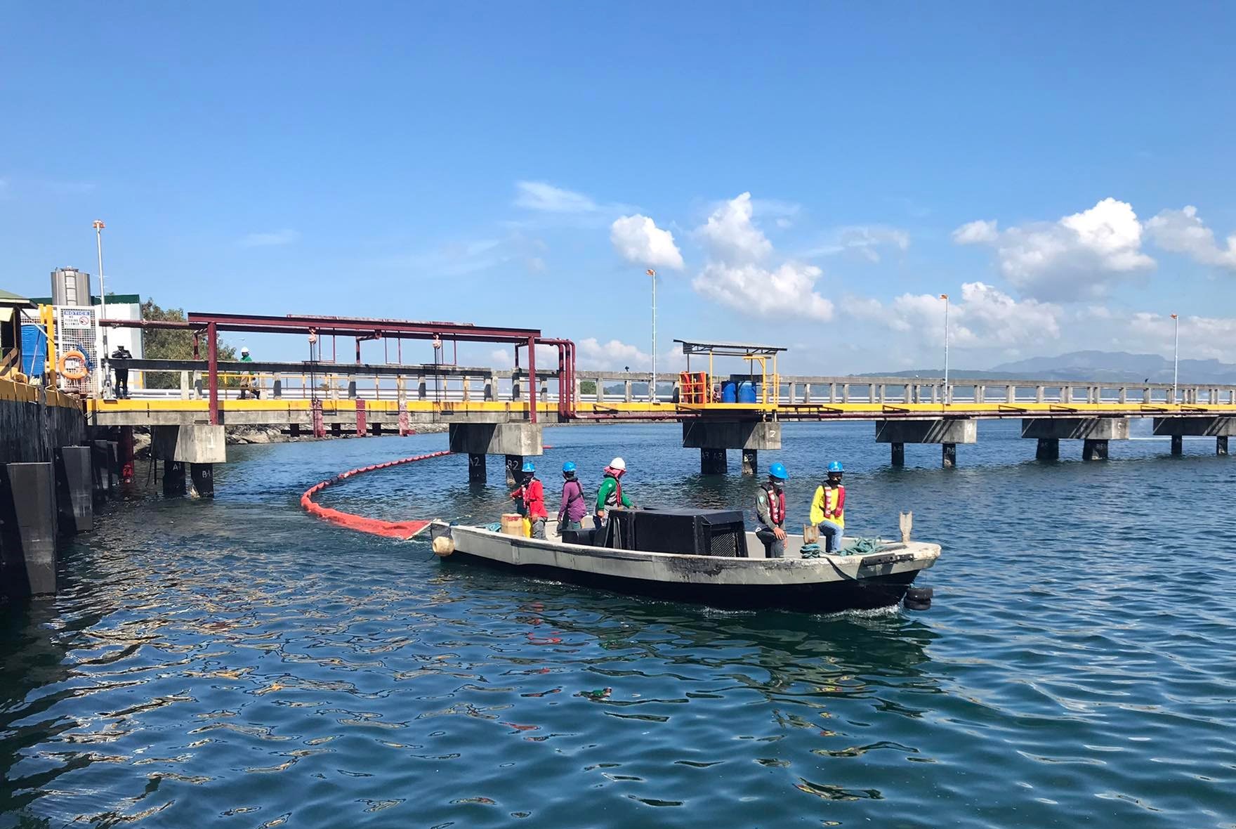 Members of the SBMA Seaport Emergency Response Team lay down a containment boom at the Boton Wharf during an oil spill simulation exercise on Friday