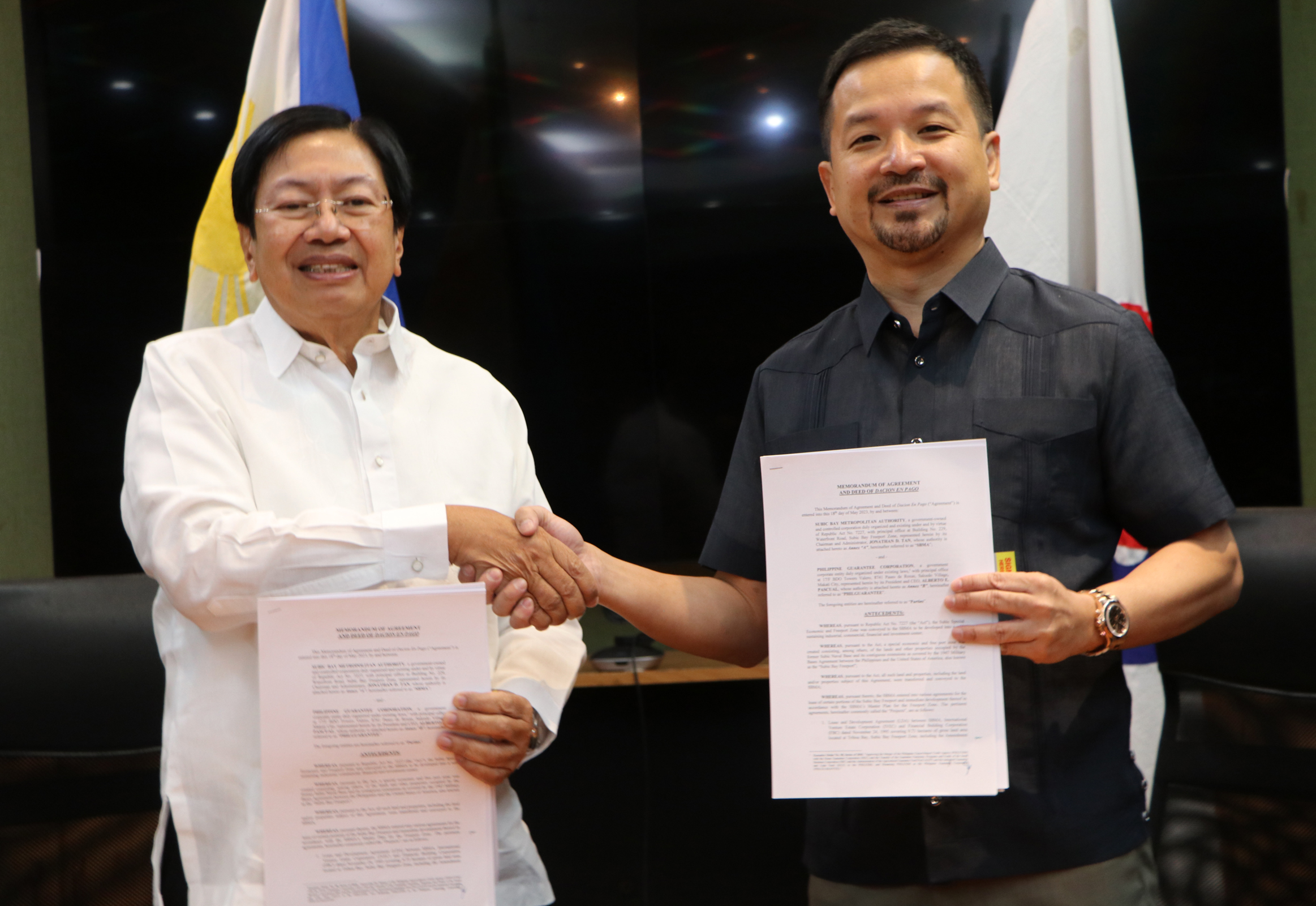 Subic Bay Metropolitan Authority (SBMA) Chairman and Administrator Jonathan D. Tan (right) shakes hand with Philippine Guarantee Corporation (PhilGuarantee) President and CEO Alberto E. Pascual after signing the Memorandum of Agreement and Deed of Dacion en Pago at the SBMA Board Room on Thursday, May 18.