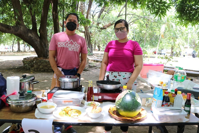 John dela Cruz, with teammate Paola Maria Santillan, both of the SBMA Regulatory group present their entry to the judges during the SBMA GAD Women&rsquo;s Month Ultimate Cook-off competition. Dela Cruz, who represented the group to the Fruit Carving competition won P10,000.