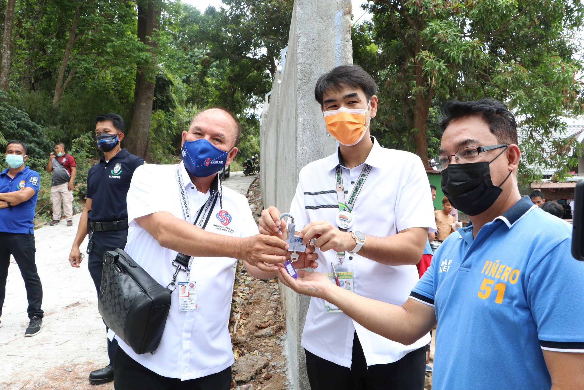 SBMA Chairman and Administrator Rolen C. Paulino symbolically shares access of the perimeter fence to Olongapo City Mayor Lenj Paulino and Barangay Captain Gilbert Piñero of East Bajac-bajac, where the Upper Sibul Elementary School is located.