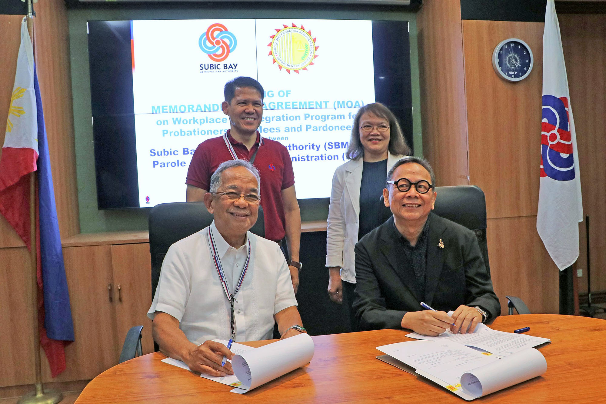 Subic Bay Metropolitan Authority (SBMA) Chairman and Administrator Eduardo Jose L. Aliño (seated, left) and Department of Justice-Parole and Probation Administration (DOJ-PPA) Administrator Atty. Bienvenido O. Benitez, Jr. sign the Memorandum of Agreement (MOA) for the workplace reintegration program for probationers, parolees and pardonees, held at the SBMA Corporate Boardroom on Thursday, April 11. Joining them are SBMA Senior Deputy Administrator for Support Services Atty. Ramon O. Agregado and DOJ-PPA Director Marissa DC Alquetra.